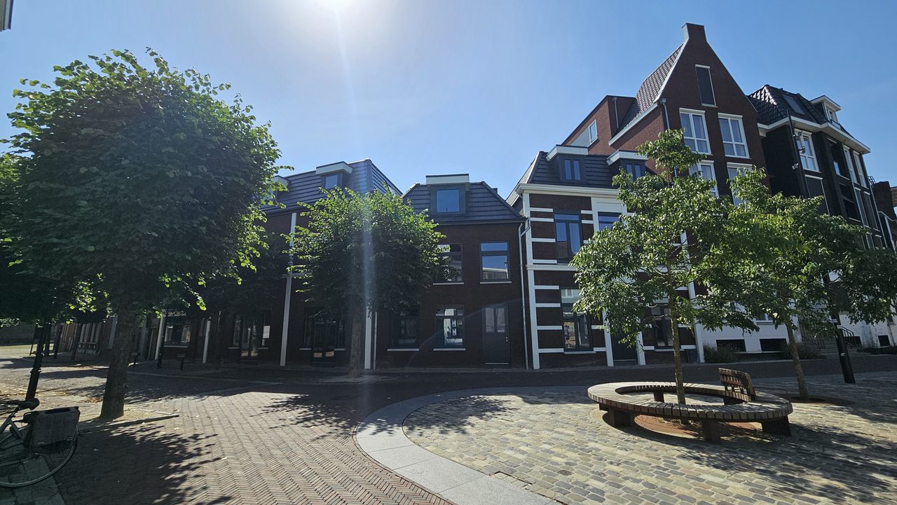 Overzicht van het plein met bomen en een ronde zitbank