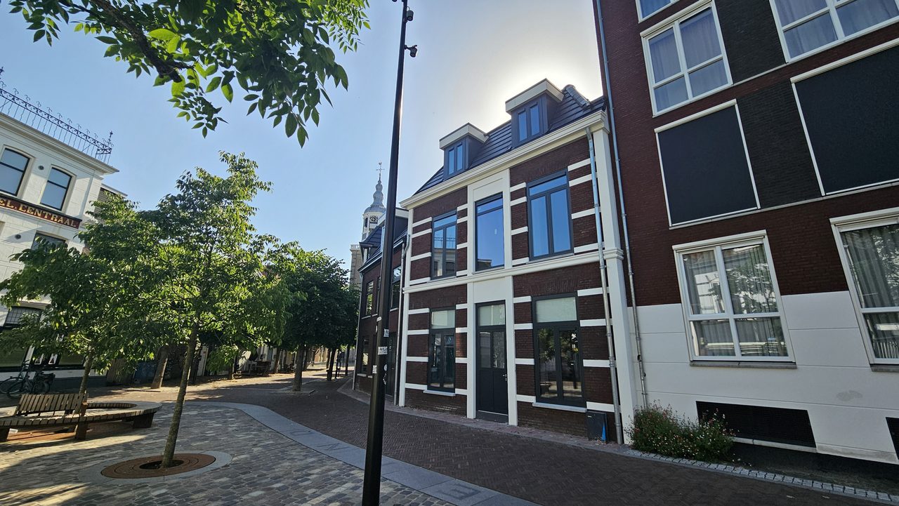 Het gerestaureerde pand aan de Kerkstraat in Almelo, gezien vanaf het plein met de kerktoren op de achtergrond