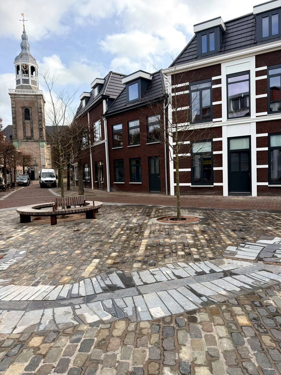 Het plein met de kerktoren op de achtergrond, bij winters licht