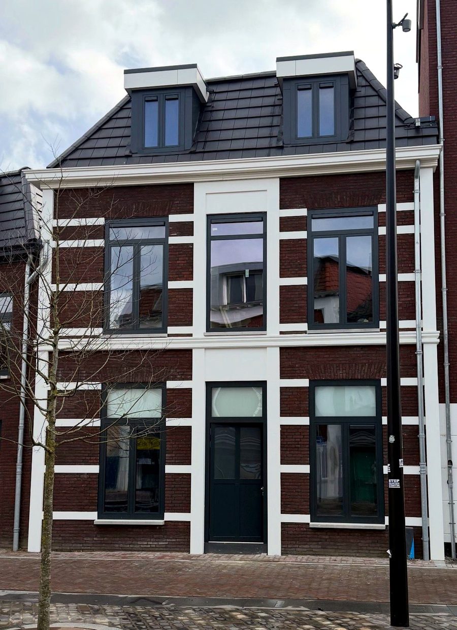Gerestaureerde straatgevel met witte speklagen, bij winters licht