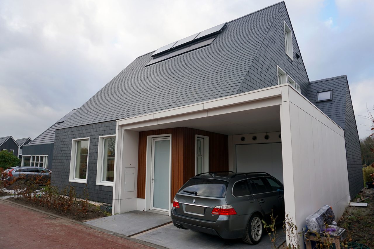 Entreezijde van de woning met carport onder het doorlopende dak