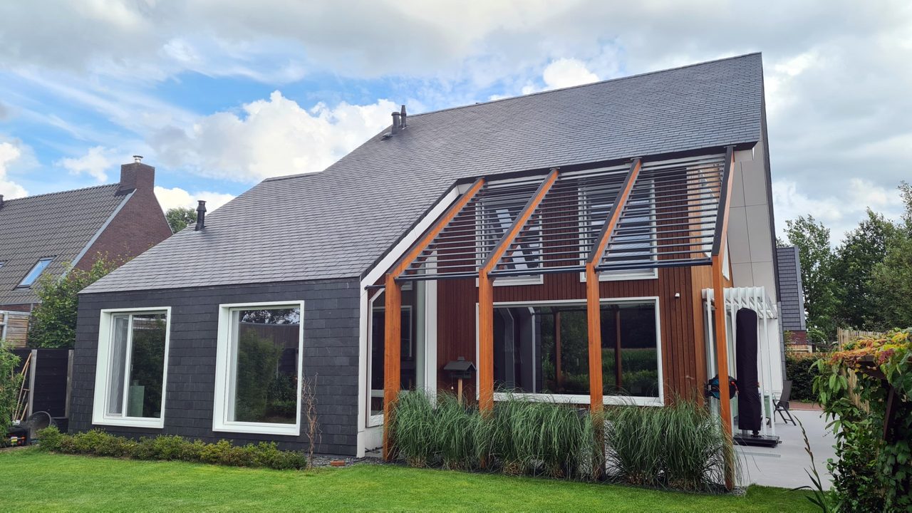 Tuinzijde van de energieneutrale woning in Zuidlaren, met een grote pui achter een houten constructie
