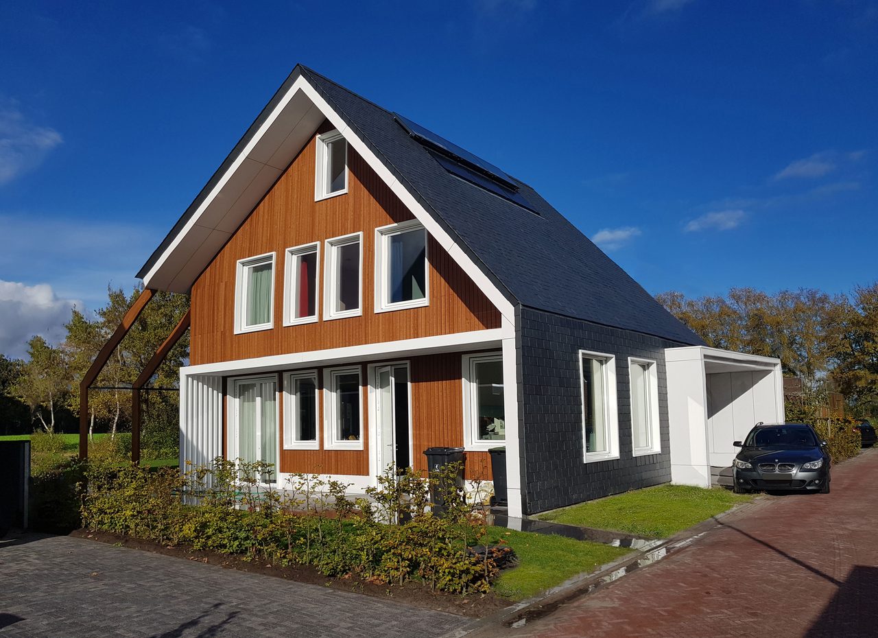Voorzijde van de energieneutrale woning in Zuidlaren, houten gevel onder een leien dakvlak