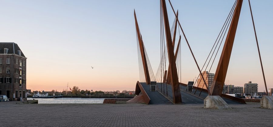 De pylonen van de brug gezien vanaf de Bomhaven bij avondlicht