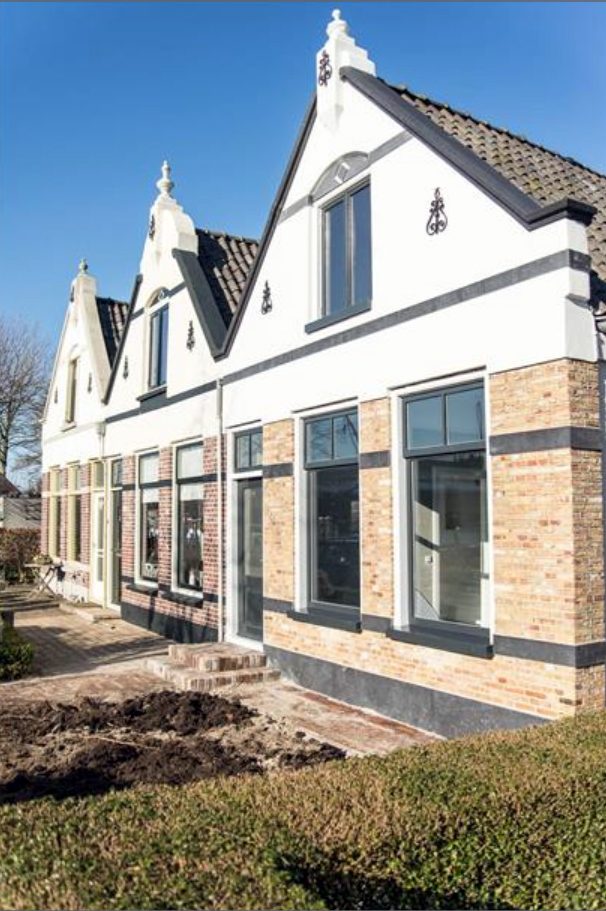 Gerenoveerde arbeiderswoning in Meppel met witte topgevels en een bakstenen onderbouw