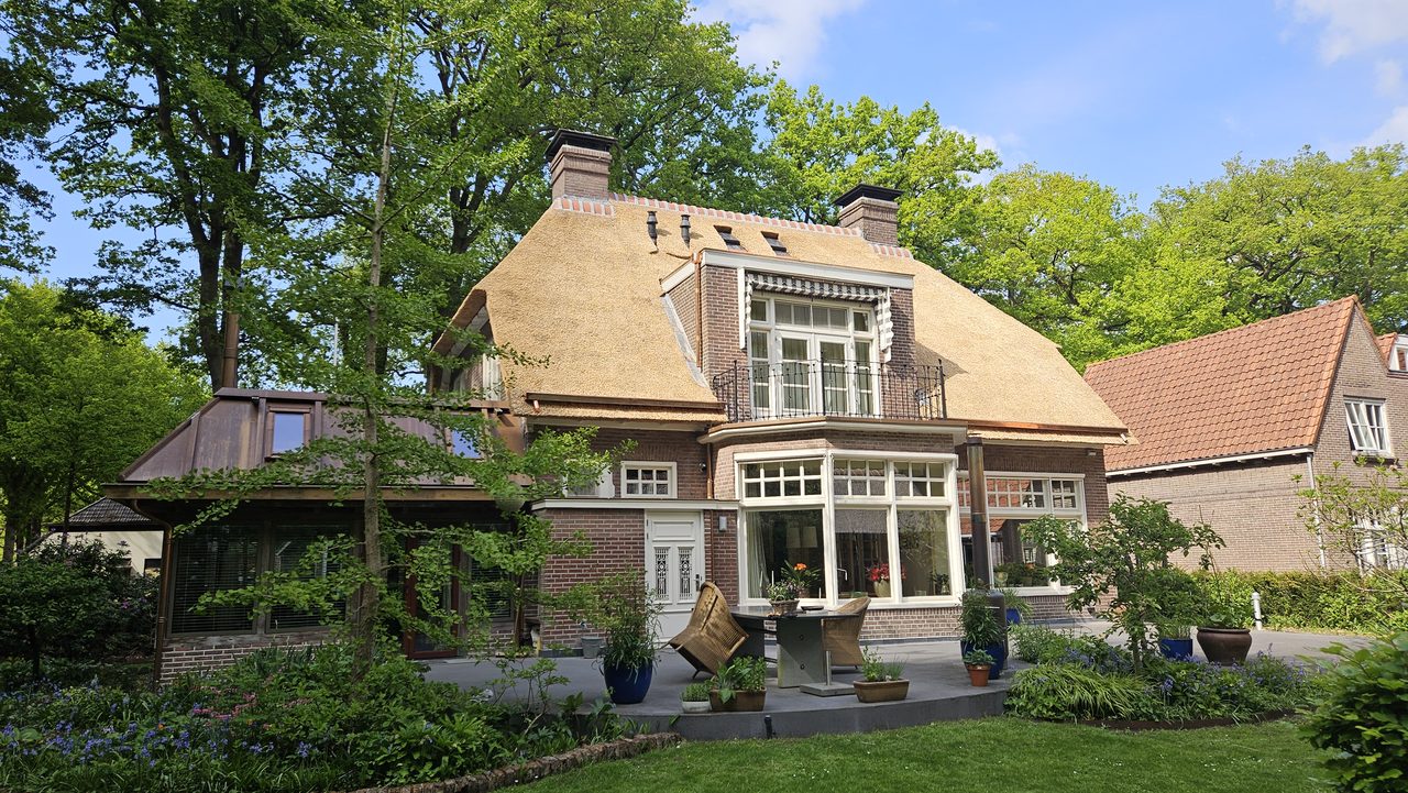 Villa met rieten kap in Zuidlaren, met aan de tuinzijde een serre onder een koperen dak