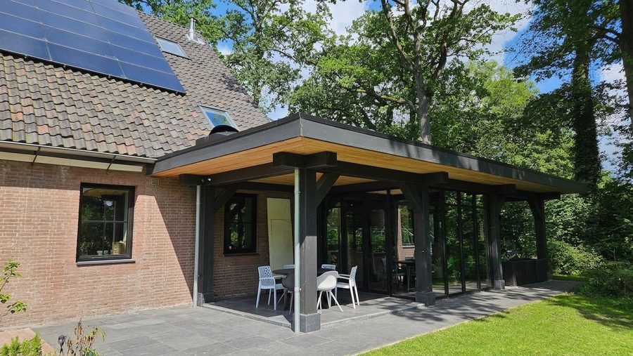 De veranda vanaf de hoek van het huis, met zonnepanelen op het bestaande dakvlak