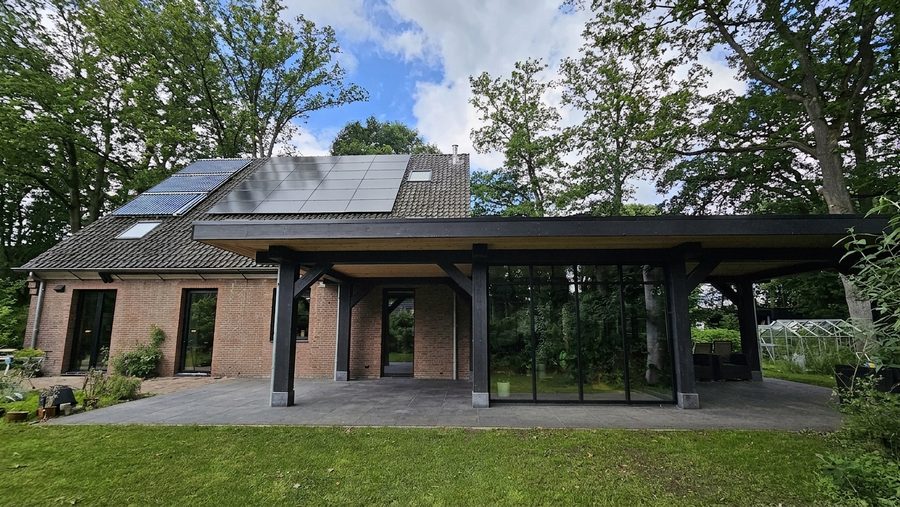 Zijaanzicht met zonnepanelen op het dakvlak en de veranda over de volle breedte eronder